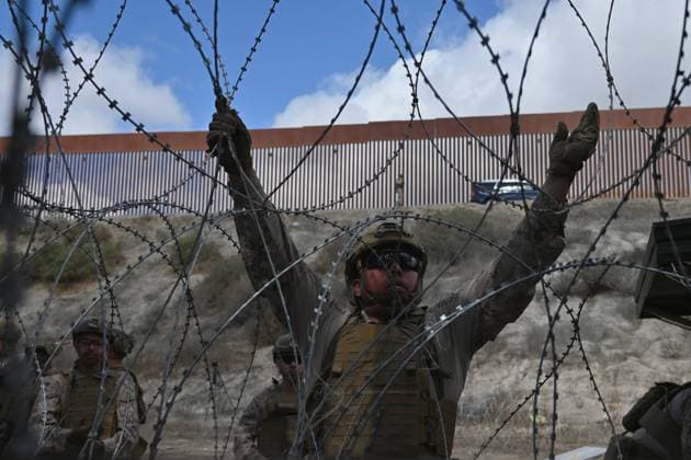 February 6, 2025, Tijuana, Baja California, Mexico: A member of the US Marine Corps installing concertina wire along the US-Mexico border wall in San Diego, California, seen from Tijuana, Mexico in between the San Diego-Tijuana border fences of Colonia Libertad on Thursday, February 06, 2025. The Defense Department deployed 1,600 active-duty troops to the border during US President Donald Trump s first week in office. Tijuana Mexico - ZUMAm180 20250206_zip_m180_010 Copyright: xCarlosxA.xMorenox