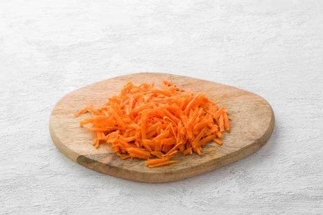 Holzbrett mit geriebenen Karotten auf hellgrauem Hintergrund, Ansicht von oben Wooden board with grated carrots on a light gray background, top view. Copyright: xZoonar.com OlgaxLepeshkinax 22764519