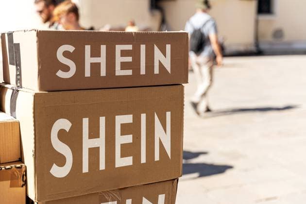 Bavaria, Germany - February 11, 2025: PHOTOMONTAGE, stacked parcels from Shein in the sun - a symbol of the boom in online retail and the fast fashion industry in China. *** FOTOMONTAGE, gestapelte Pakete von Shein in der Sonne Symbol für den Boom des Online-Handels und die Fast-Fashion-Industrie auch China.