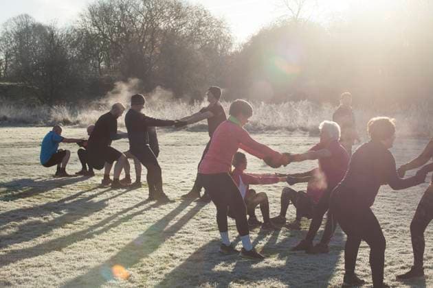 IMAGO Creative, Winter, In der Stadt A group of adults engage in a team exercise in a frosty park on a sunny morning, creating a chain through linked arms. Sale Water Park, Manchester, UK Manchester United Kingdom swmi00531 Copyright: xConnectxImagesx ,model released
