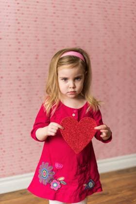 Valentine s portrait of serious little girl in red holding heart Canada, British Columbia, Sparwood R_PKZL250210-1644657-01 ,model released, Symbolfoto