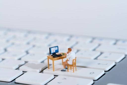 IMAGO Creative, Architektur, Zukunftsmodell Tiny flats a man sits at his desk in the home office on a white keyboard, closeup 18674954 RECORD DATE NOT STATED