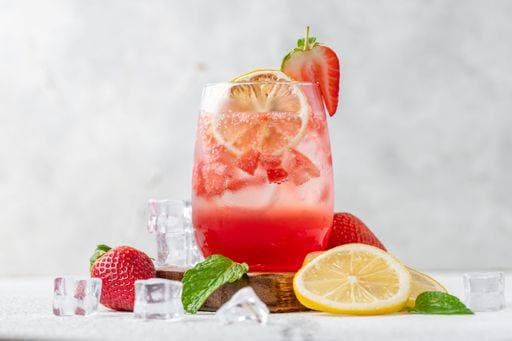 A pitcher of freshly prepared strawberry mojito cocktail garnished with colorful fruit pieces. 21948594 RECORD DATE NOT STATED