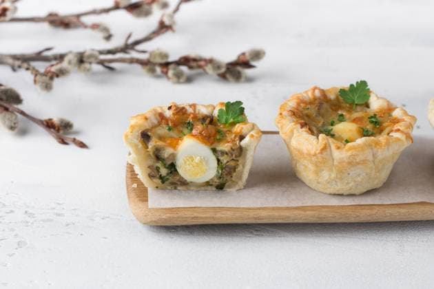 Pilz-Julienne mit Wachtelei und Käse in einem Blätterteigkorb auf hellblauem Hintergrund. Ostern Stil mit Weidenzweigen Mushroom julienne with quail egg and cheese in a puff pastry basket on a light blue background. Easter style with willow branches. Copyright: xZoonar.com OlgaxLepeshkinax 22864279