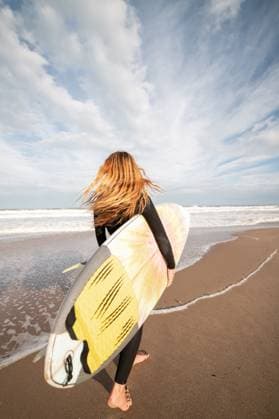 Creative Highlights Symbolfotos MR_PaulaAgulleiro_BlondeWomanSurf.jpg Full body back view of sportive female surfer in black wetsuit walking on wet shore near waving sea during training Model Released LeoPastor_ID18058_543292_060 Copyright: xLeoxPastorx