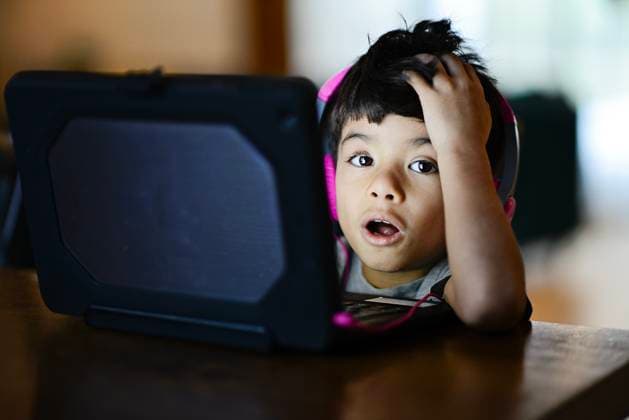Creative Highlights Symbolfotos Young boy with headphones reacts in surprise while using a table United States, Florida, Crystal River R_YWQX250218-1645370-01 ,model released, Symbolfoto