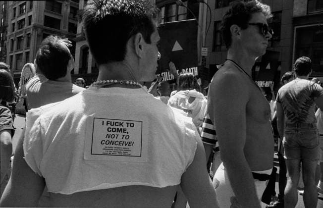 man wears sticker reading I fuck to come not to conceive! during NYC Pride March in New York City, USA on June 28th 1992 *** man wears sticker reading I fuck to come not to conceive during NYC Pride March in New York City, USA on June 28th 1992