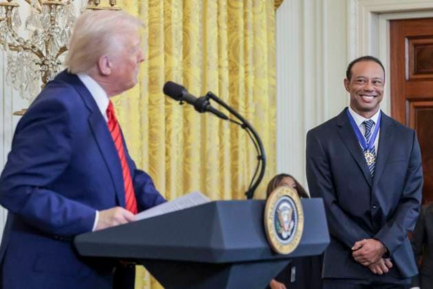 Golfer Tiger Woods (R) listens to US President Donald J. Trump (L) during a reception honoring Black History Month in the East Room of the White House in Washington, DC, on February 20, 2025.  WAX20250220802 SHAWNxTHEW
