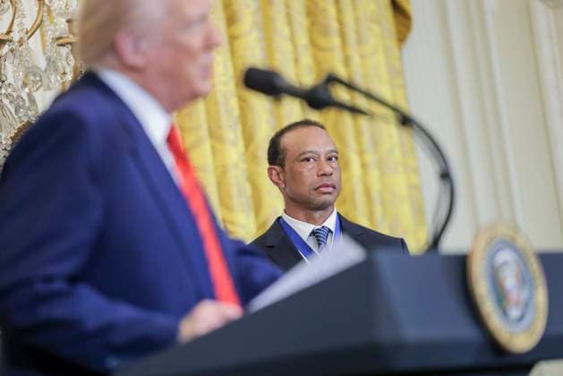 Golfer Tiger Woods (R) listens to US President Donald J. Trump during a reception honoring Black History Month in the East Room of the White House in Washington, DC, on February 20, 2025.  WAX20250220810 SHAWNxTHEW