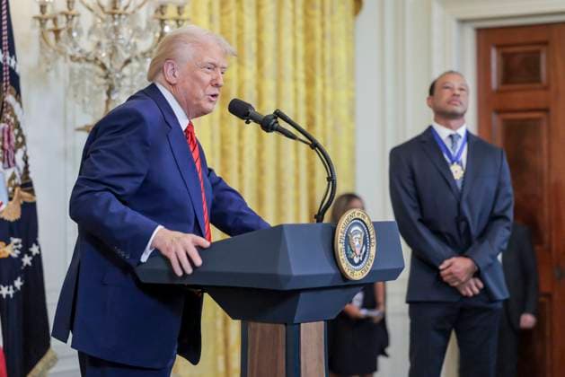 US President Donald J. Trump delivers remarks while standing with golfer Tiger Woods during a reception honoring Black History Month in the East Room of the White House in Washington, DC, on February 20, 2025.  WAX20250220850 SHAWNxTHEW