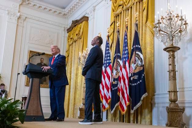 US President Donald J. Trump, with US professional golfer Tiger Woods, walks on stage to deliver remarks during a reception honoring Black History Month in the East Room of the White House in Washington, DC, on February 20, 2025.  WAX20250220860 SHAWNxTHEW