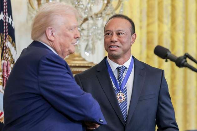 US President Donald J. Trump (L) and golfer Tiger Woods (R) during a reception honoring Black History Month in the East Room of the White House in Washington, DC, on February 20, 2025.  WAX20250220868 SHAWNxTHEW