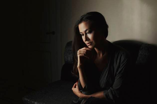 Creative Highlights Symbolfotos Thoughtful woman sitting at home in low light model released, Symbolfoto, AZF00631