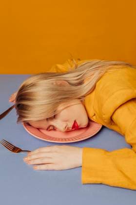 Creative Highlights Symbolfotos Stylish woman in yellow clothing resting her head on a plate with a vibrant background model released, Symbolfoto, VSNF02886