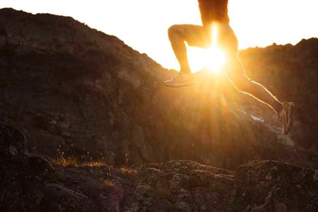 Creative Highlights Symbolfotos Trail run athlete leaps through the air with the sunburst behind. Canada, British Columbia, Whistler CR_PSFZ250223A-1642012-01 ,model released, Symbolfoto