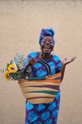 Creative Highlights Symbolfotos Smiling African woman holding sunflowers and a large woven bag Madrid, Community of Madrid, Spain CR_CRVI250224-1653991-01 ,model released, Symbolfoto