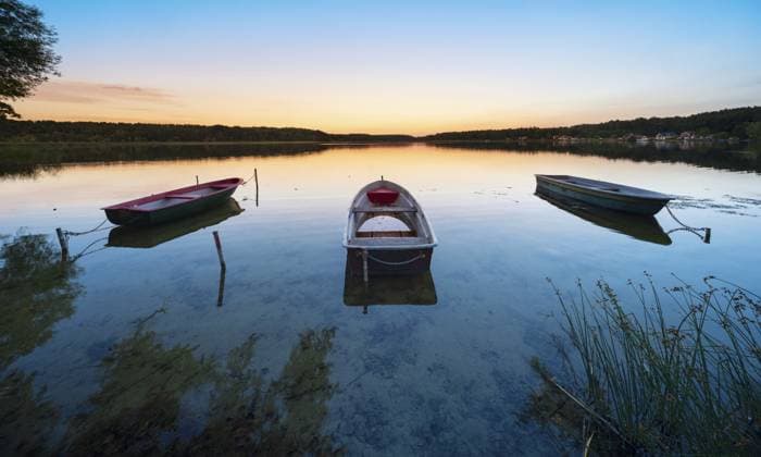 Ruderboote liegen vertäut im stillen Wasser eines Sees am Abend, Wutzsee, Lindow (Mark), Brandenburg, Deutschland, Europa Rowing boats moored in the calm waters of a lake in the evening, Wutzsee, Lindow (Mark), Brandenburg, Germany, Europe Copyright: imageBROKER AVTG ibxkcv12803252.jpg