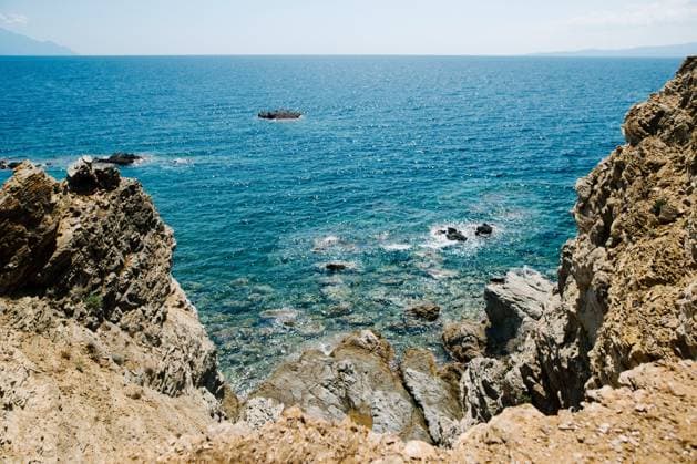 Scenic Rocky Coastline with Clear Blue Waters Ouranoupoli, Greece R_JUCE2502268F-1669317-01