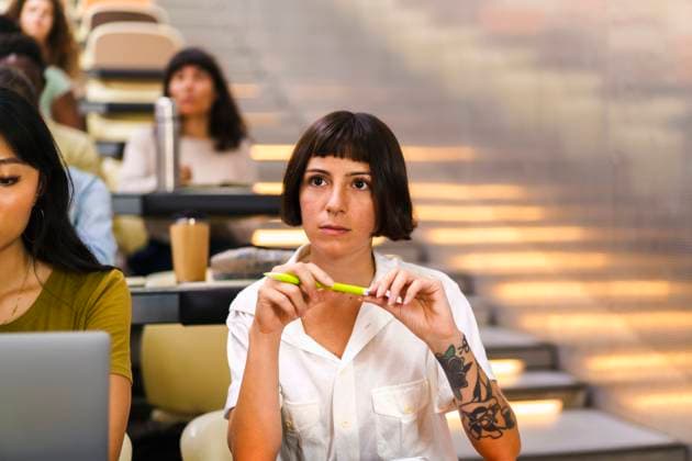Creative Highlights Symbolfotos Female student with pen sitting at lecture hall in university Germany, Berlin, model released, property released Copyright: xMaskotx , MA116368 MA116368