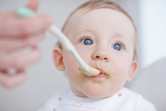 Creative Highlights Symbolfotos Baby, parent hands and feeding in home, hungry and love to support with child development. Childcare, high chair and helping son to eat food, nutrition and healthy meal for infant diet or wellness. model released property released Copyright: xx