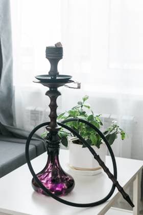Hookah shisha with glass flask and metal bowl in room background. Traditional Eastern vacation for relaxation. , 52029022.jpg, hookah, shisha, smoke, eastern, house, arabian, traditional, black, relaxation, bowl, glass, metal, nargile, glowing, egyptian, breathe, smoking, east, oriental, leisure, turkish, lounge, sheesha, culture, relax, arabic, coal, table, water, restaurant, charcoal, basement, surface, indoor, narghile, tobacco, nicotine, cafe, enjoyment, asia, scene, aroma, mysterious, gallery, addiction, nobody, room, party, window, chill RECORD DATE NOT STATED