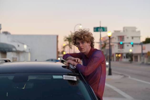 Creative Highlights Symbolfotos Young man with curly hair leaning on a car in an urban setting during sunset. Miami, FL, USA Miami Florida USA bola07432 Copyright: xConnectxImagesx ,model released