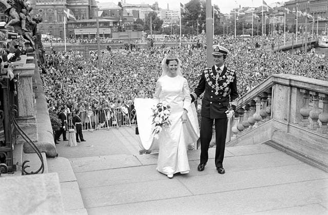 Hochzeit von Carl XVI. Gustaf und Silvia Sommerlath. Carl XVI. Gustaf, König von Schweden. Geboren am 30. April 1946. Die Hochzeit am 19. Juni 1976 in Stockholm. Königin Silvia in ihrem Hochzeitskleid mit König Carl XVI. Gustaf auf der Treppe des königlichen Schlosses in Stockholm mit einer jubelnden Menschenmenge im Hintergrund Wedding of Carl XVI Gustaf and Silvia Sommerlath. Carl XVI Gustaf, King of Sweden. Born 30 april 1946. The wedding 19 june 1976 in Stockholm. Queen Silvia in her wedding dress with king Carl XVI Gustaf on the stairway to the royal castle in Stockholm with crowds of people in the background cheering Copyright: imageBROKER Sjoberg ibljsj12891621.jpg