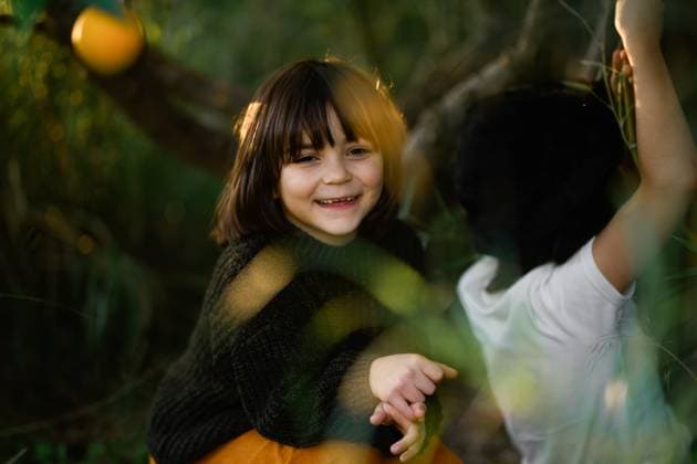 Creative Highlights Symbolfotos MR_ID26943_20137_LeoBosquetLaguna.jpg, MR_ID26943_20138_MayaBosquetCarli.jpg A joyful moment captured between two children playing outdoors. The girl in the foreground is smiling brightly, surrounded by lush greenery and sunlight, reflecting a carefree day. Model Released MagdalenaCarli_ID26943_777386_002 Copyright: xMagdalenaxCarlix RECORD DATE NOT STATED