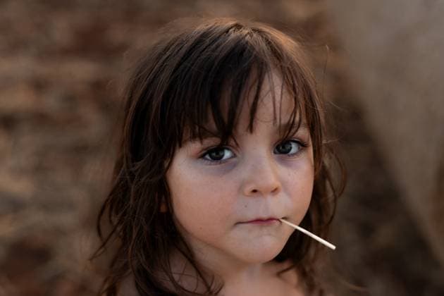 Creative Highlights Symbolfotos A thoughtful child with long hair gazes into the camera, holding a stick in their mouth. The soft, neutral background enhances the focus on the child s expressive eyes. Model Released MagdalenaCarli_ID27200_782264_003 Copyright: xMagdalenaxCarlix