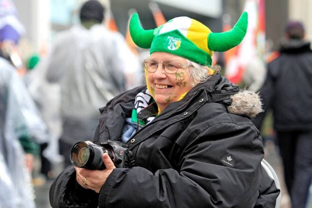 St. Patrick s Day Parade In Downtown Toronto, Canada, On March 16, 2025. A spectator wears a festive hat and photographs participants while watching the St. Patrick s Day parade in Toronto, Canada, on March 16, 2025. Toronto Canada  Copyright: xMikexCampbellx originalFilename: campbell-notitle250317_np081.jpg