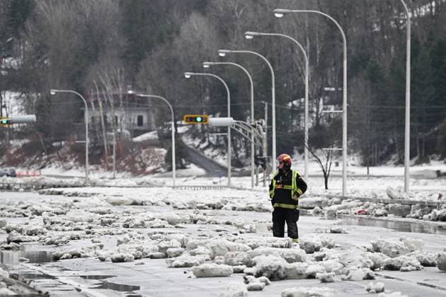 March 17, 2025, Beauceville, Pq, Canada: A firefighter stands in the middle of blocks of ice on highway 173 in Beauceville, Que., Monday, March 17, 2025. The Chaudiere river flooded the city after an ice blockage overnight. Beauceville Canada  - ZUMAc35_ 20250317_zaf_c35_088 Copyright: xJacquesxBoissinotx