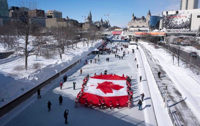 February 14, 2025, Ottawa, On, Canada: Local youth skate with a large Canadian flag on the Rideau Canal to launch celebrations for the 60th Anniversary of the National Flag of Canada Day, Friday, Feb. 14, 2025 in Ottawa. Ottawa Canada  - ZUMAc35_ 20250214_zaf_c35_191 Copyright: xAdrianxWyldx