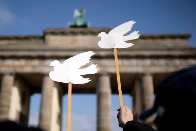 Friedensdemonstration DEU, Deutschland, Germany, Berlin, 15.03.2025 Demonstranten mit Schild Symbol weisse Friedenstaube auf der Kundgebung und Demonstration der deutschen Friedensbewegung organisiert von Friedensinitiativen Friko und linken Parteien unter dem Motto Keine Grunsgesetzaenderung fuer Aufruestungsorgie und Kriegstuechtigkeit Reden statt ruesten Haende Weg vom Grundgesetz Keine Neuen Kriegskredite Nein zu Kriegen und Hochruestung Ja zu Frieden und soziale Friedenspolitik nach der Sondersitzung fuer eine Aenderung vom Grundgesetz zum Thema Schuldenbremse und Sondervermoegen vor dem Brandenburger Tor in Berlin Deutschland . Gefordert werden Friedensverhandlungen sowie Ende der Sanktionen und den Krieg Ukraine gegen Russland , Ende