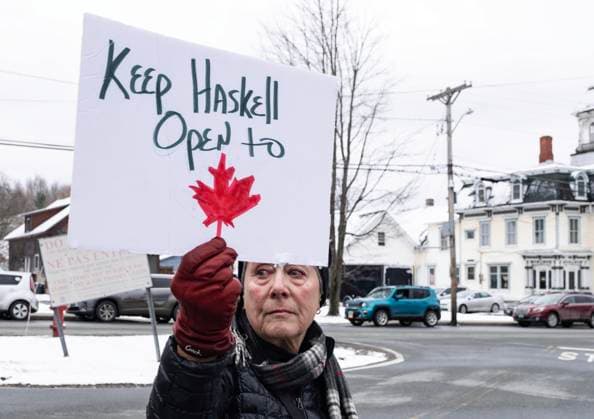 March 21, 2025, Stanstead, Qc, Canada: Penny Thomas who drove from Newport, Vt., has a tear roll down her cheek as she holds a sign on the standing in Derby, Vt., outside the Haskell Free Library and Opera House in Stanstead, Que., on Friday, March 21, 2025. The town of Stanstead, Que., says U.S. authorities have unilaterally decided to close the main Canadian access to the Victorian-style library that straddles the border between the two countries. Stanstead Canada - ZUMAc35_ 20250321_zaf_c35_018 Copyright: xChristinnexMuschix