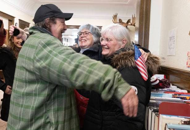 March 21, 2025, Derby Line, Vt, USA: Byron Wright, left, from Derby, Vermont, gives Pauline Lussier, centre from Stanstead, Quebec and Chris Blais from Derby Line, Vermont, a hug as they straddle the international border line inside the Haskell Free Library and Opera House in Derby Line on Friday, March 21, 2025. The town of Stanstead says U.S. authorities have unilaterally decided to close the main Canadian access to the Victorian-style library that straddles the border between the two countries. Derby Line USA - ZUMAc35_ 20250321_zaf_c35_038 Copyright: xChristinnexMuschix