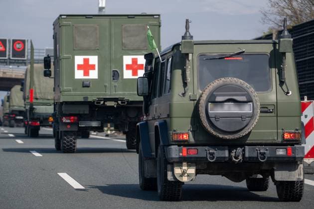 A9, Germany - 23 March 2025: Military vehicles with camouflage livery and Lithuanian license plates (unrecognizable) are driving on the A9. In the convoy is a medical vehicle with two red crosses and a green flag. *** Militärfahrzeuge mit Tarnlackierung und litauischem Kennzeichen (unkenntlich) fahren auf der A9. Im Konvoi befindet sich ein Sanitätsfahrzeug mit zwei roten Kreuzen und grüner Fahne.