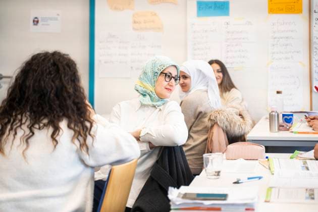 Woman in green hijab participating in a multicultural language learning class model released, Symbolfoto property released, NJAF01660