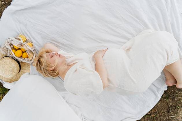 Creative Highlights Symbolfotos Pregnant woman relaxing outdoors on a blanket with lemons and a straw hat model released, Symbolfoto, NDEF02230