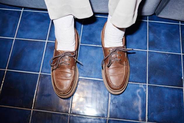 Creative Highlights Symbolfotos Close up of feet wearing brown leather shoes on blue tiled floor model released, Symbolfoto property released, KPEF00909