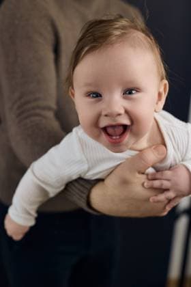 Creative Highlights Symbolfotos Laughing baby held by father, joyful family moment Pilsen, Plze? Region, Czechia R_NAJJ250322D7-1689819-01 ,model released, Symbolfoto