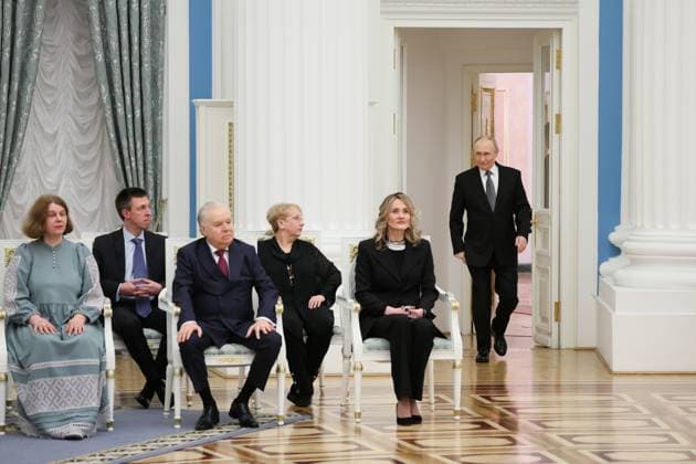 RUSSIA, MOSCOW - MARCH 25, 2025: Russia s President Vladimir Putin (R back) enters the hall for a ceremony in the Kremlin to present Russian Presidential Prizes in Culture, Literature and Art for Year 2024 to young professionals for their works aimed at children and youth. Sergei Savostyanov TASS  79356598