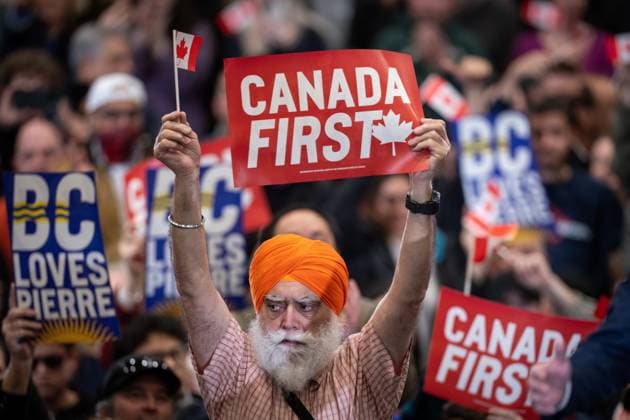 March 27, 2025, Surrey, Bc, CANADA: A man holds a Canada First sign as Conservative Leader Pierre Poilievre, not seen, speaks during a campaign rally in Surrey B.C., on Thursday, March 27, 2025. Surrey CANADA  - ZUMAc35_ 20250327_zaf_c35_097 Copyright: xEthanxCairnsx