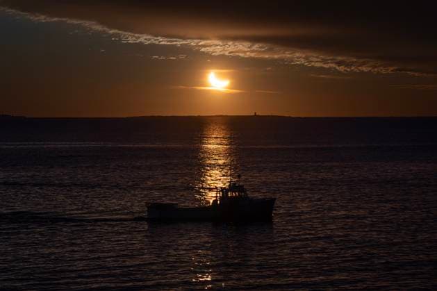 March 29, 2025, Halifax, Ns, Canada: A fishing boat is silhouetted during a partial solar eclipse in Halifax on Saturday, March 29, 2025. Halifax Canada  - ZUMAc35_ 20250329_zaf_c35_001 Copyright: xDarrenxCalabresex