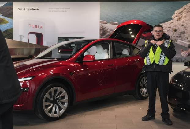 March 29, 2025, Vancouver, Bc, CANADA: A police officer stands inside a Tesla showroom as people protest outside, in Vancouver, on Saturday, March 29, 2025. Vancouver CANADA  - ZUMAc35_ 20250329_zaf_c35_057 Copyright: xDarrylxDyckx