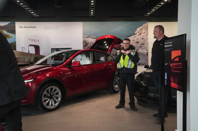March 29, 2025, Vancouver, Bc, CANADA: A police officer talks with an employee in a Tesla showroom as people protest outside, in Vancouver, on Saturday, March 29, 2025. Vancouver CANADA  - ZUMAc35_ 20250329_zaf_c35_050 Copyright: xDarrylxDyckx