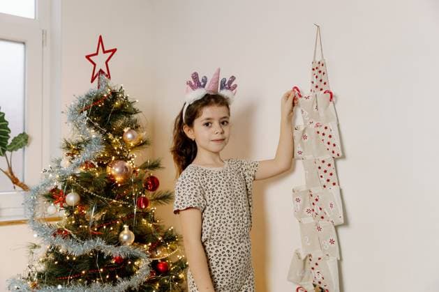 One beautiful Caucasian brunette girl with a unicorn horn headband stands by the Christmas tree and with her hand takes out a lollipop from a pocket with the number two of an advent calendar in the morning in the living room, close-up side view., model released, , 57074186.jpg, christmas, background, smile, christmas tree, child, person, girl, house, kid, winter, indoors, lollipop, candy, new, room, red, home, seasonal, surprise, taking, tradition, xmas, year, present time, holiday, advent, handmade, emotions, calendar, happy, lights, shy, santa, creative, decoration, cover, gift, hanging, december, lifestyle, people, preschooler, get, cute, wicker, banner, wallpaper, poster, children, childhood RECORD DATE NOT STATED