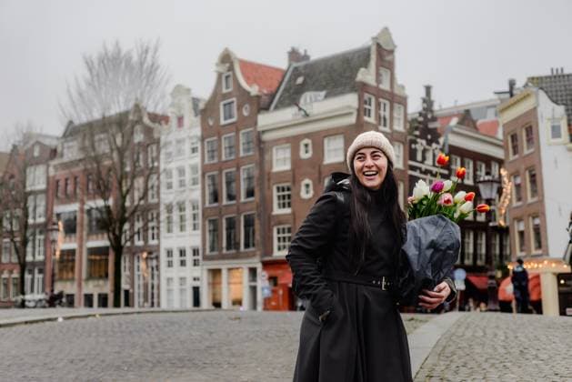 IMAGO Creative, Winter, In der Stadt Joyful Woman Holding Tulips in Wintertime Amsterdam Street Scene Amsterdam, North Holland, Netherlands CR_ASAC250401-1636584-01 ,model released, Symbolfoto