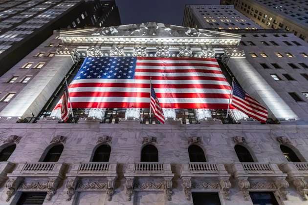 New York Stock Exchange NYSE Building In The Night Night view of the illuminated exterior of New York Stock Exchange with a big American flag from the front facade. NYSE building has the style of classical architecture of Greece with columns, the inscription New York Stock Exchange and US flags hanging. The financial organization at Wall Street is a symbol for the global and American Economy as one of the most powerful financial institution located in Wall Street at lower Manhattan in New York City, United States of America. The US stock market is reacting with heavy losses after president Trump tariffs announcement on April 2025. November 2024 in NYC, USA New York City Netherlands  Copyright: xNicolasxEconomoux originalFilename: economou-notitle241110_npZXH.jpg