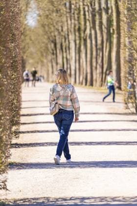 IMAGO Creative, Ostern, Bräuche, Osterspaziergang #2 Frau geht einen baumgesäumten Weg entlang. Frühlingsstimmung und entspannte Atmosphäre bei sonnigem Wetter, Schlossgarten Schwetzingen, Deutschland, Europa Woman walking along a tree-lined path. Spring mood and relaxed atmosphere in sunny weather, Schwetzingen Palace Gardens, Germany, Europe Copyright: imageBROKER ManuelxKamuf ibxmlk12952356.jpg ,model released, Symbolfoto ,property released