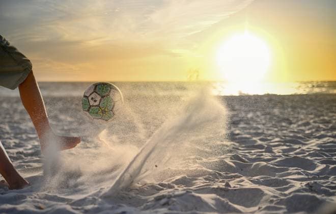 Boy kicking ball on beach towards beautiful sunset on the horizon Adelaide, South Australia, Australia R_PAOL250404-1698006-01 ,model released, Symbolfoto
